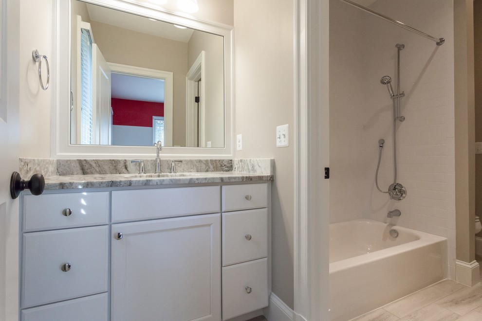 Alcove bathtub - transitional kids' white tile and subway tile beige floor alcove bathtub idea in DC Metro with recessed-panel cabinets, white cabinets, beige walls, an undermount sink and beige countertops