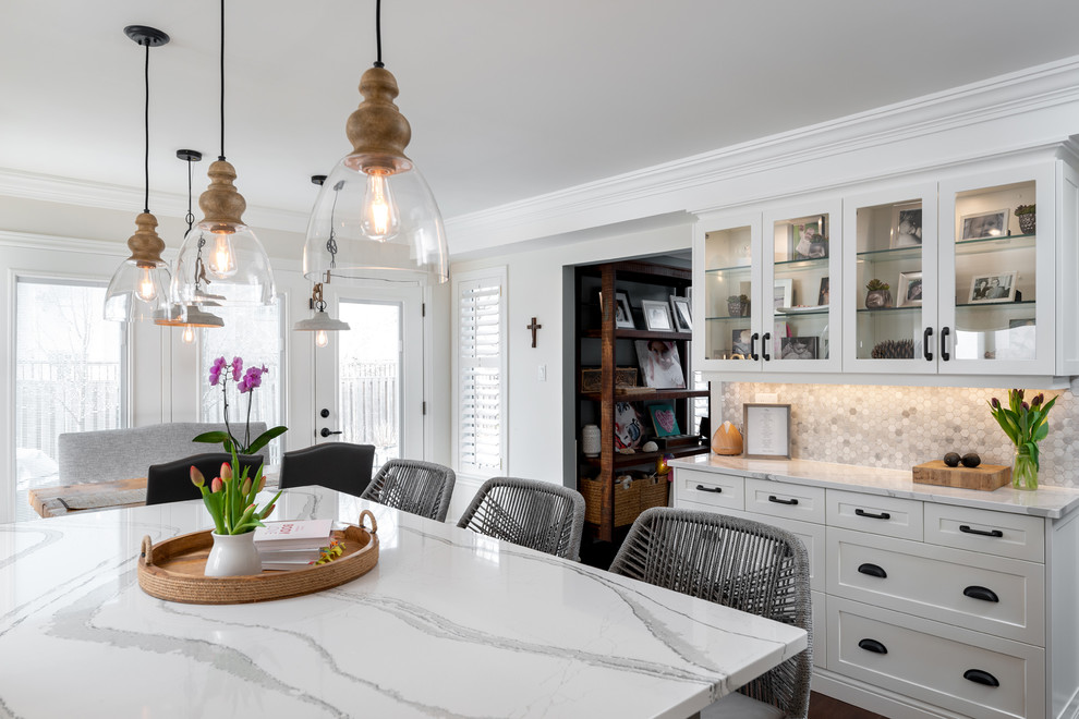 Transitional dark wood floor and brown floor kitchen photo with white cabinets, quartz countertops, paneled appliances, an island and white countertops