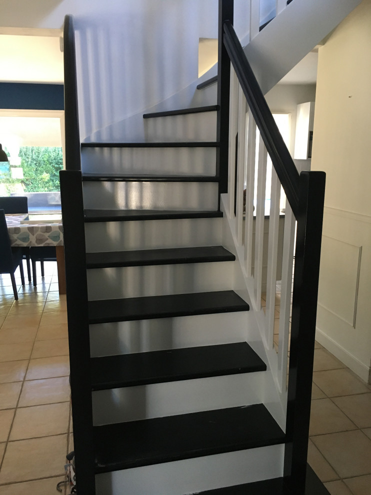 Стильный дизайн: изогнутая лестница среднего размера в стиле модернизм с крашенными деревянными ступенями, крашенными деревянными подступенками и деревянными перилами - последний тренд