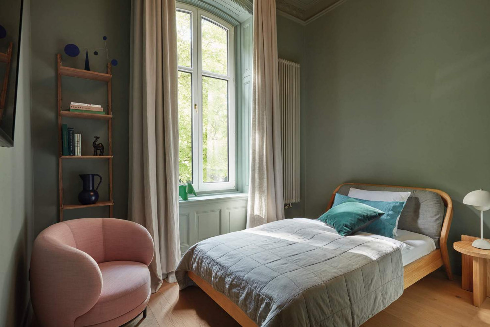 Aménagement d'une petite chambre d'amis rétro avec un mur vert, parquet clair, un sol marron et boiseries.