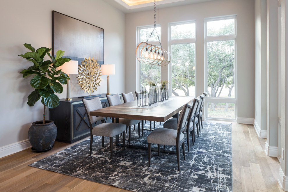 Photo of a transitional dining room in Austin with grey walls and medium hardwood floors.