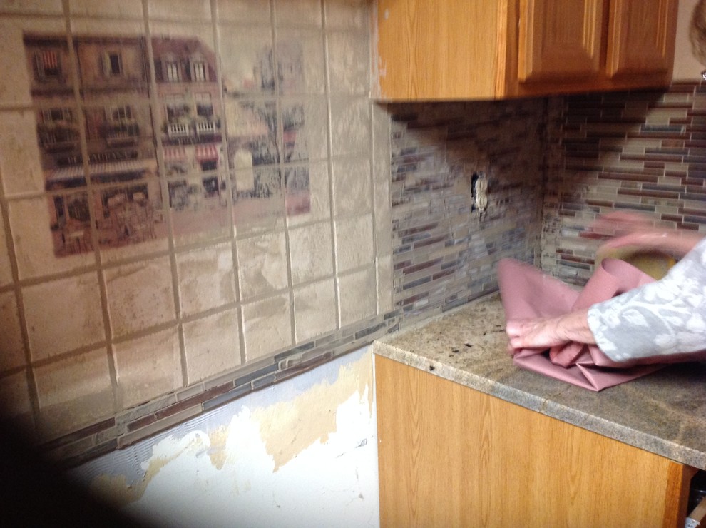 Inspiration for a l-shaped eat-in kitchen remodel with an undermount sink, flat-panel cabinets, brown backsplash, glass tile backsplash, stainless steel appliances and a peninsula