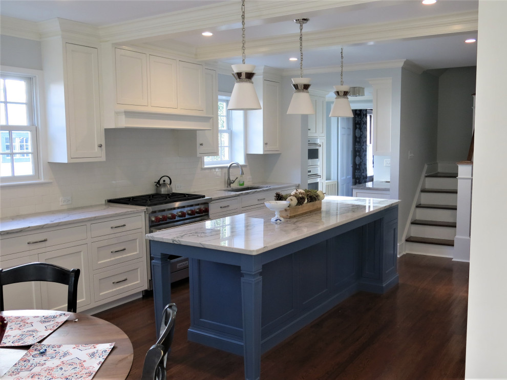 Inspiration for a transitional eat-in kitchen remodel with flat-panel cabinets, white cabinets, white backsplash, an island and white countertops