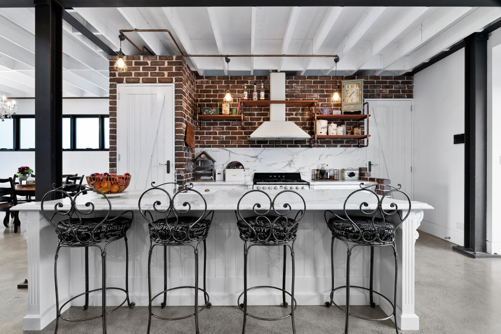 Mid-sized urban galley concrete floor, gray floor and exposed beam open concept kitchen photo in Sydney with a farmhouse sink, shaker cabinets, white cabinets, marble countertops, multicolored backsplash, marble backsplash, colored appliances, an island and multicolored countertops