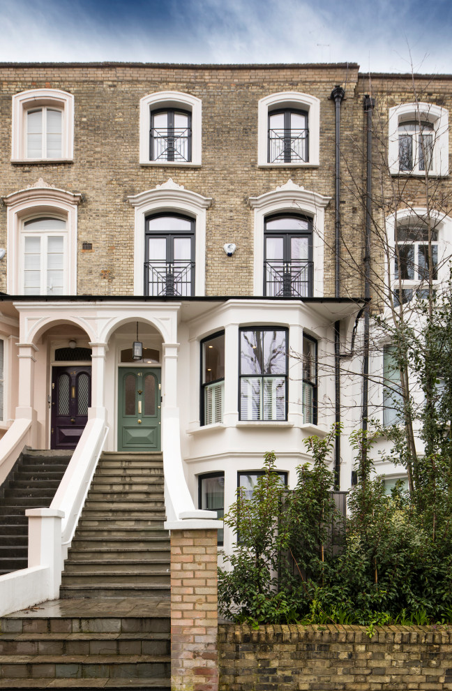 Large traditional brick beige townhouse exterior in London with four or more storeys.