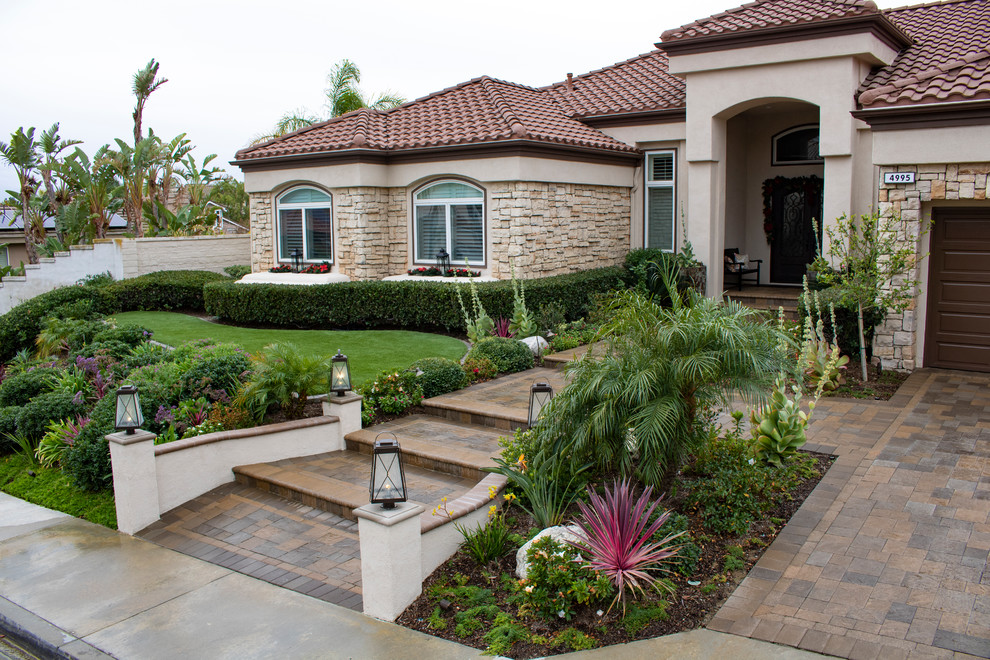 Inspiration for a large mediterranean front yard full sun driveway in Orange County with concrete pavers and a garden path.