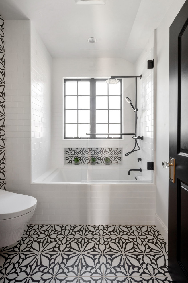 Immagine di una stanza da bagno mediterranea con vasca sottopiano, vasca/doccia, WC sospeso, pareti bianche, pavimento con piastrelle in ceramica, nicchia e mobile bagno freestanding