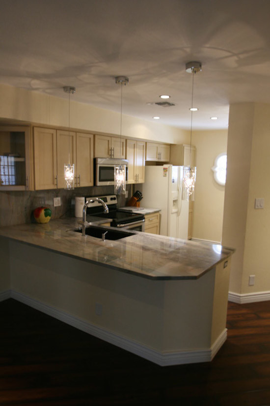 Enclosed kitchen - mid-sized transitional l-shaped dark wood floor and brown floor enclosed kitchen idea in Phoenix with an undermount sink, shaker cabinets, light wood cabinets, granite countertops, beige backsplash, stone slab backsplash, stainless steel appliances and a peninsula