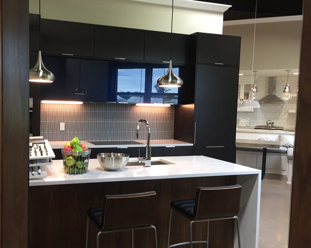 Contemporary single-wall eat-in kitchen in Grand Rapids with an undermount sink, flat-panel cabinets, dark wood cabinets, solid surface benchtops, grey splashback, cement tile splashback, stainless steel appliances and with island.