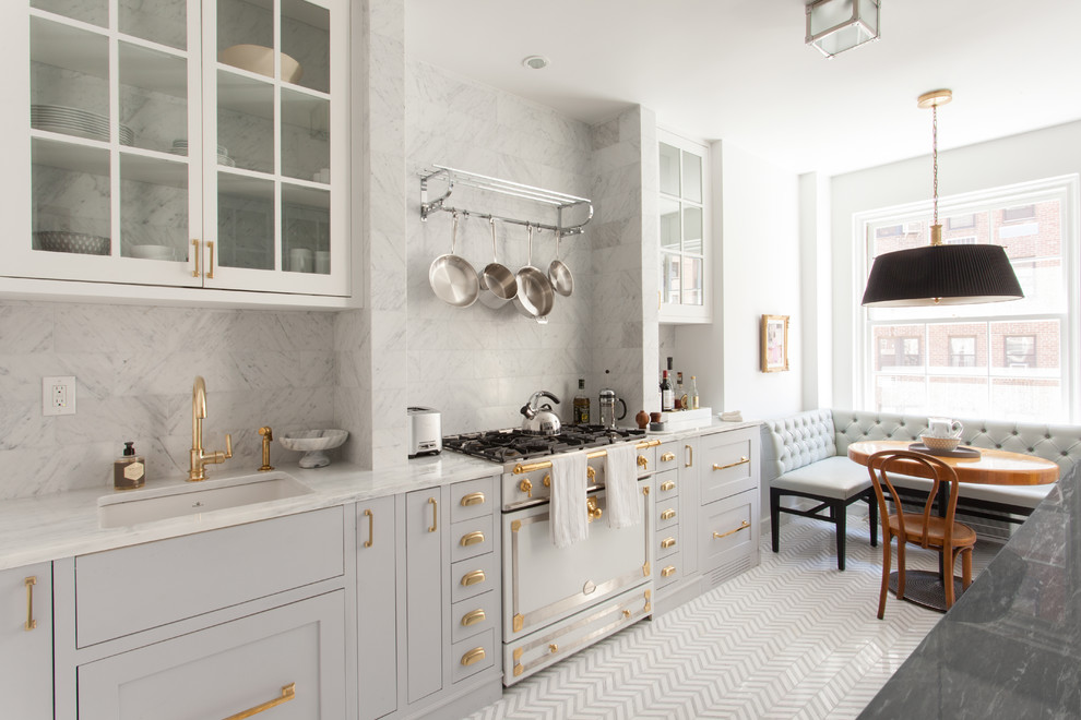Design ideas for a traditional single-wall eat-in kitchen in New York with an undermount sink, flat-panel cabinets, grey cabinets, marble benchtops, grey splashback, stone tile splashback, porcelain floors, no island and white appliances.