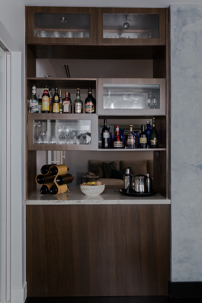 This is an example of a small contemporary single-wall home bar in Los Angeles with flat-panel cabinets, dark wood cabinets and dark hardwood floors.