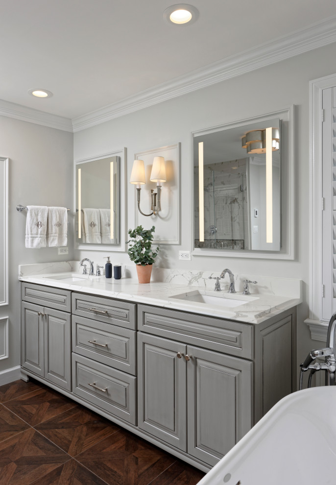 Inspiration for a traditional bathroom in DC Metro with furniture-like cabinets, grey cabinets, a freestanding tub, a corner shower, a two-piece toilet, white tile, marble, grey walls, wood-look tile, an undermount sink, engineered quartz benchtops, brown floor, a hinged shower door, white benchtops, a shower seat, a double vanity, a freestanding vanity and decorative wall panelling.