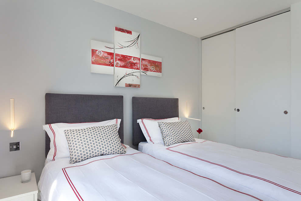 This is an example of a medium sized contemporary guest bedroom in London with grey walls.