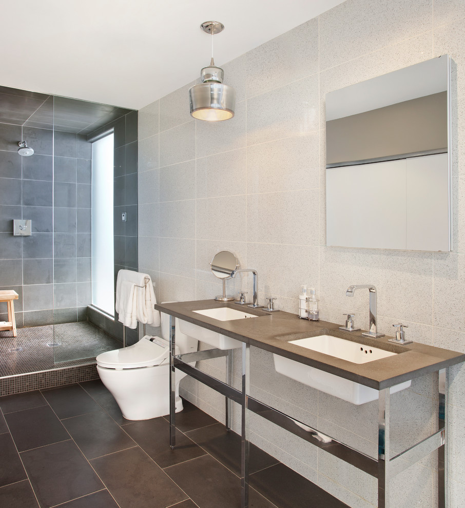 This is an example of a contemporary bathroom in Chicago with an undermount sink, an open shower, white tile, an open shower and grey benchtops.
