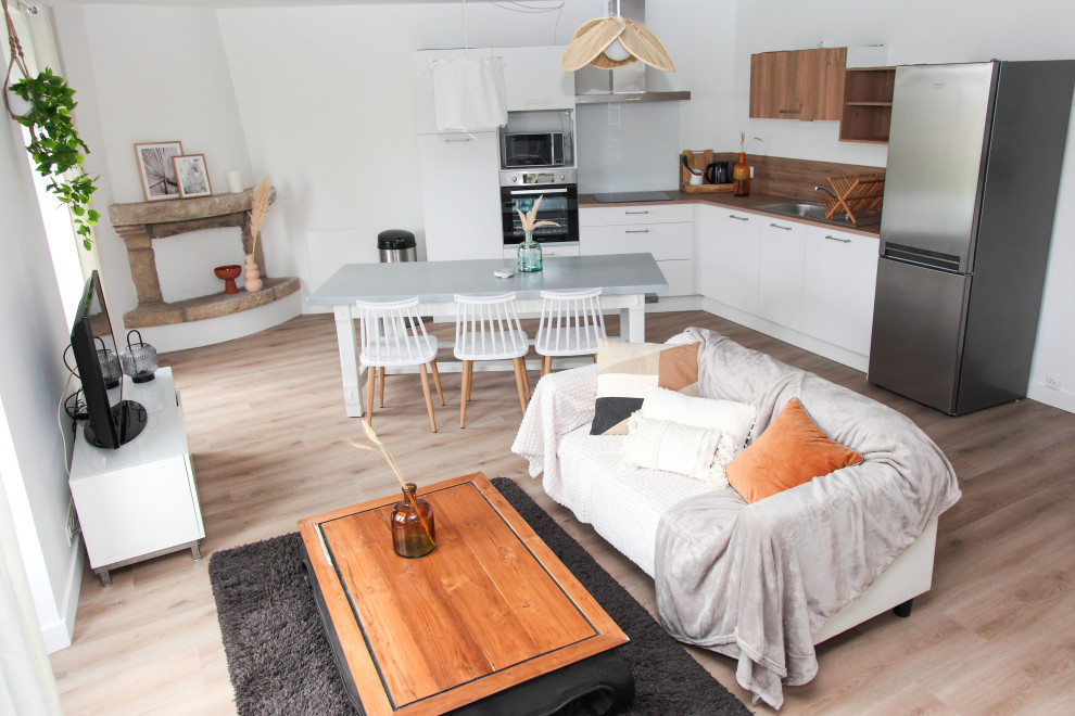 Großes, Offenes Mediterranes Wohnzimmer mit weißer Wandfarbe, hellem Holzboden, Eckkamin, Kaminumrandung aus Stein und braunem Boden in Rennes