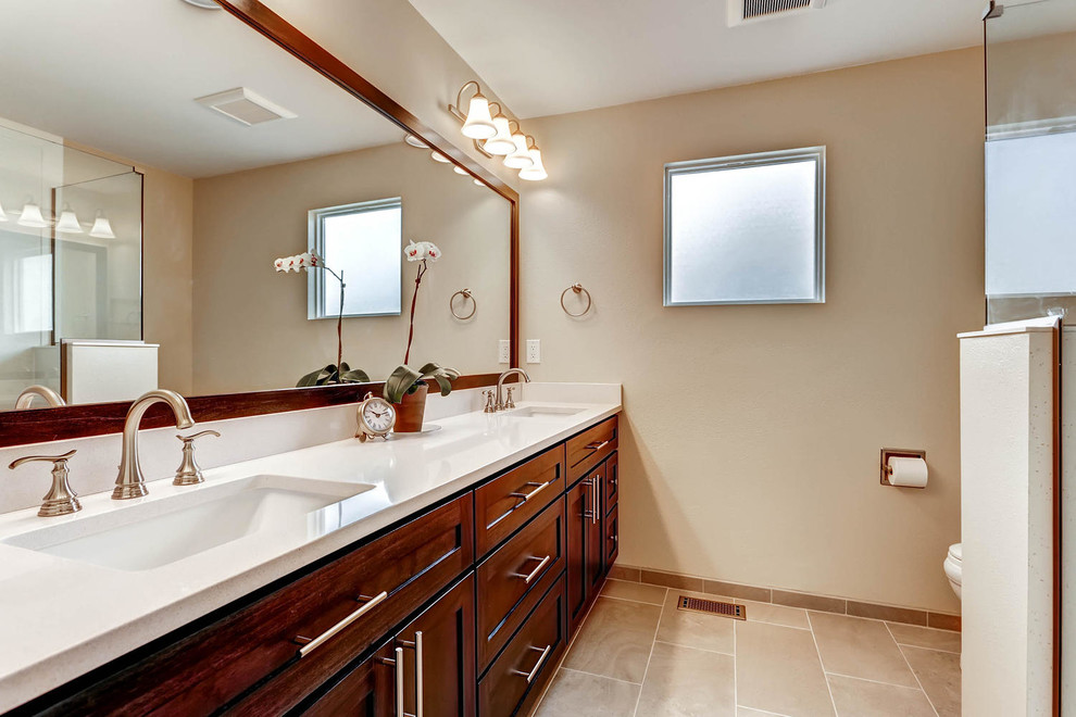 Doorless shower - small transitional master cement tile ceramic tile doorless shower idea in Denver with shaker cabinets, dark wood cabinets, a one-piece toilet, beige walls, an undermount sink and quartz countertops
