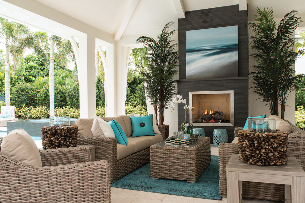 Large beach style backyard tile patio photo in Miami with a roof extension and a fireplace