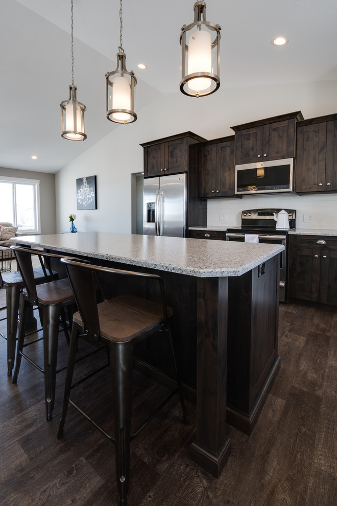 Example of a mid-sized transitional l-shaped open concept kitchen design with shaker cabinets, dark wood cabinets, laminate countertops, stainless steel appliances and an island