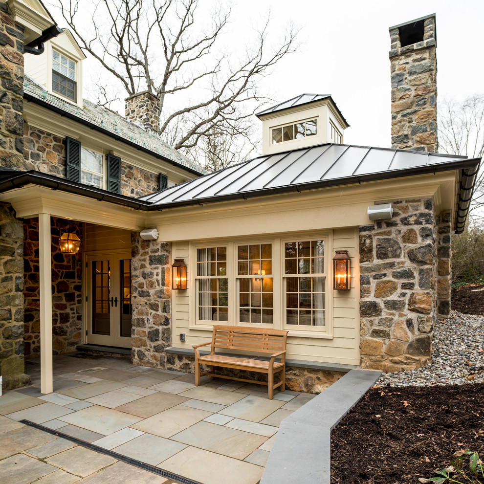 This is an example of a mid-sized traditional backyard patio in Philadelphia with natural stone pavers and no cover.