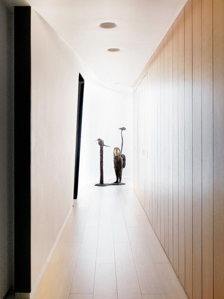 Design ideas for a mid-sized modern hallway in Los Angeles with light hardwood floors.