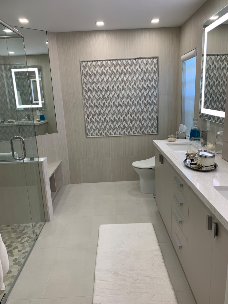 Example of a mid-sized minimalist master multicolored tile and ceramic tile ceramic tile, gray floor and double-sink bathroom design in Miami with flat-panel cabinets, beige cabinets, a one-piece toilet, beige walls, an undermount sink, quartz countertops, a hinged shower door, white countertops and a built-in vanity