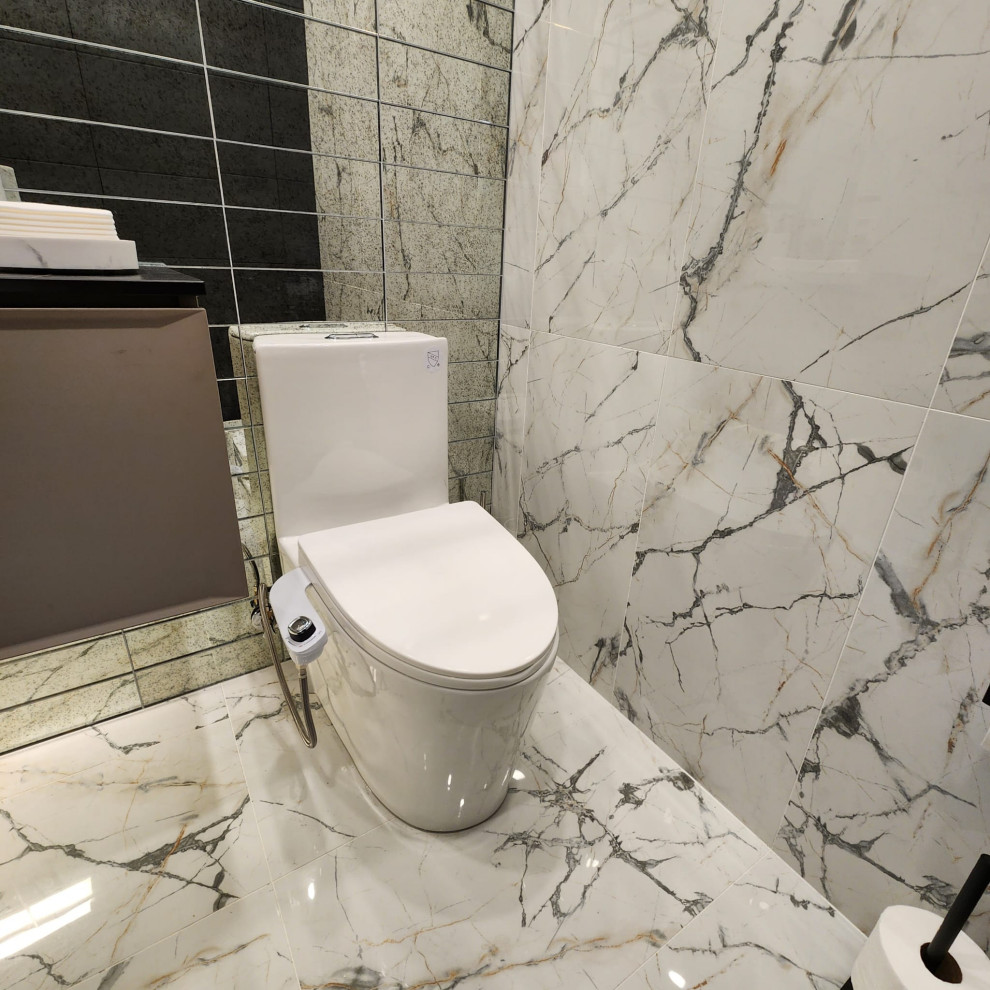 Bild på ett litet funkis svart svart toalett, med släta luckor, bruna skåp, en toalettstol med hel cisternkåpa, vit kakel, porslinskakel, vita väggar, klinkergolv i porslin, bänkskiva i kvartsit och vitt golv