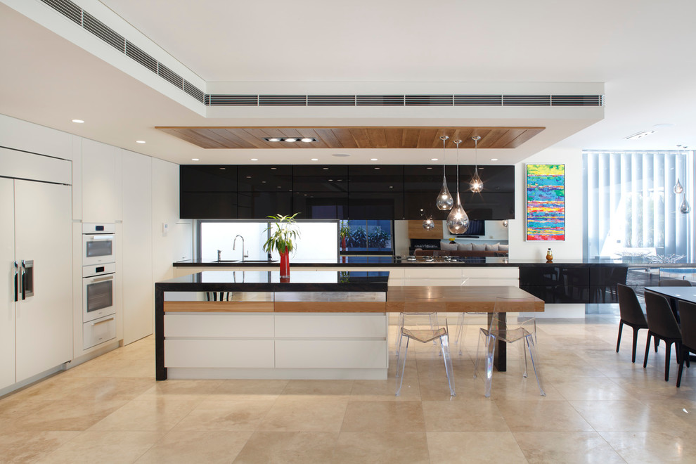 This is an example of a mid-sized contemporary kitchen in Sydney with white cabinets, black splashback, with island, flat-panel cabinets and travertine floors.