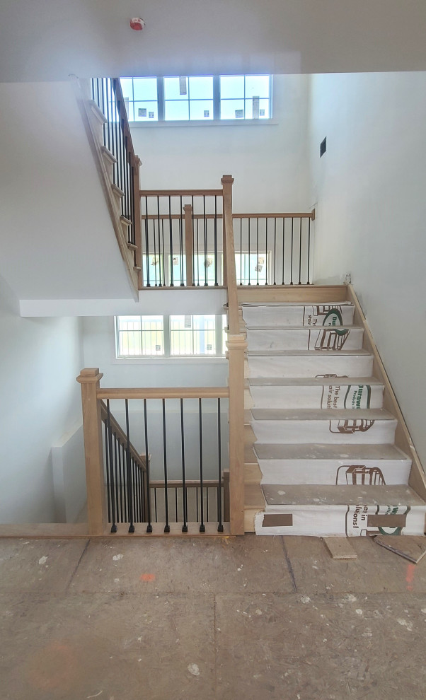Large contemporary wood l-shaped staircase in New York with wood risers and mixed railing.