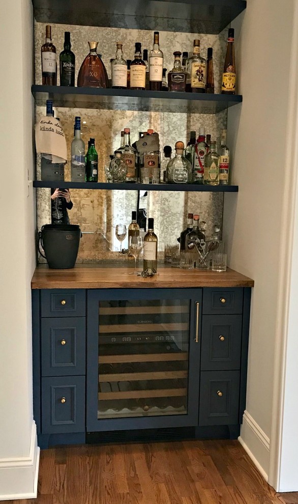 Photo of a small transitional single-wall wet bar in Philadelphia with no sink, beaded inset cabinets, blue cabinets, wood benchtops, mirror splashback, medium hardwood floors, brown floor and brown benchtop.