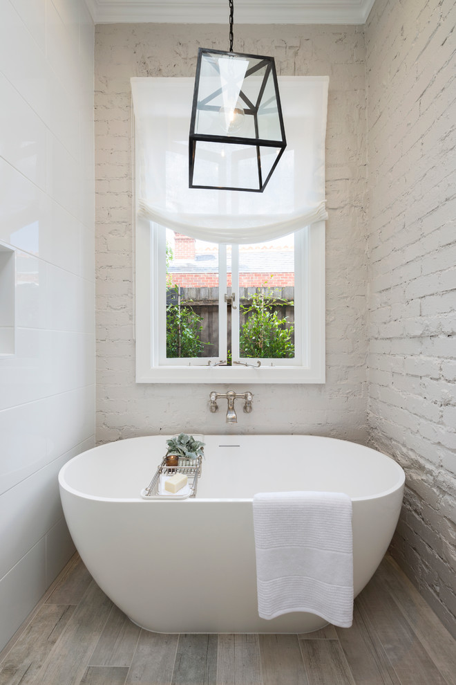 This is an example of a contemporary bathroom in Melbourne with white tile, white walls, porcelain floors, beige floor and brick walls.