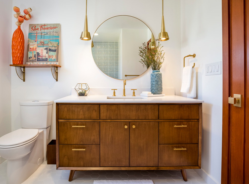 Inspiration for a mid-sized midcentury bathroom in Los Angeles with medium wood cabinets, a shower/bathtub combo, white tile, ceramic tile, white walls, engineered quartz benchtops, a drop-in tub, a two-piece toilet, porcelain floors, an undermount sink, white floor, a hinged shower door and flat-panel cabinets.