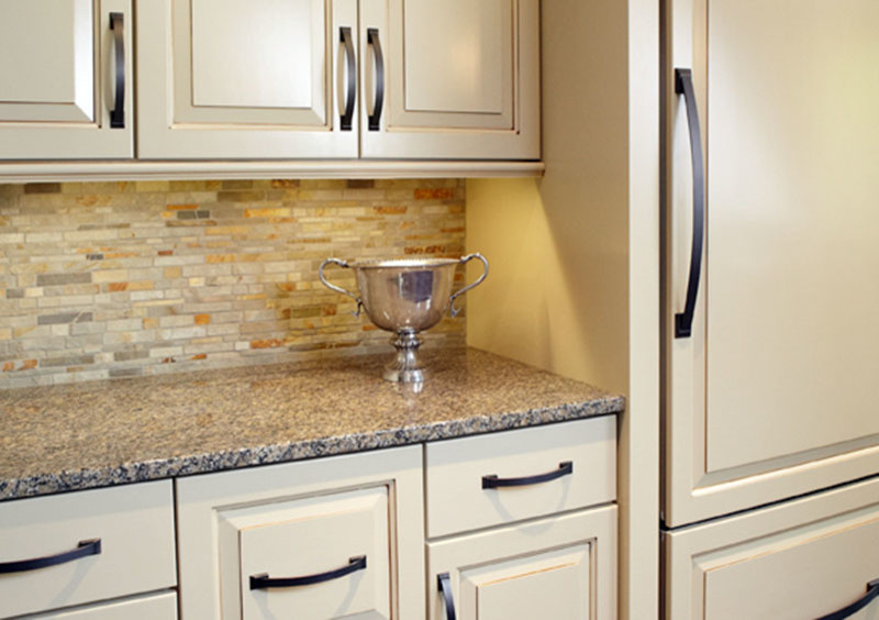 Example of a transitional dark wood floor kitchen design in Grand Rapids with white cabinets, granite countertops and an island