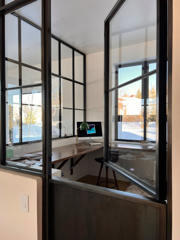 Custom glass wall with a dutch door French artist studio inspired office space
