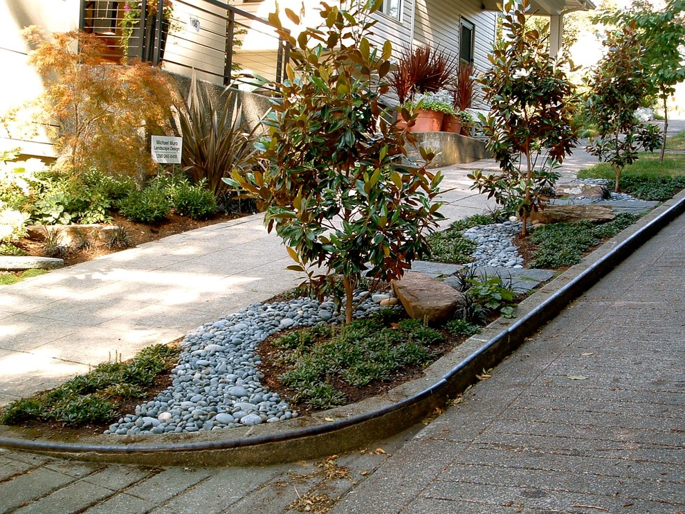Photo of a small eclectic front yard shaded garden for spring in Seattle with natural stone pavers and a garden path.