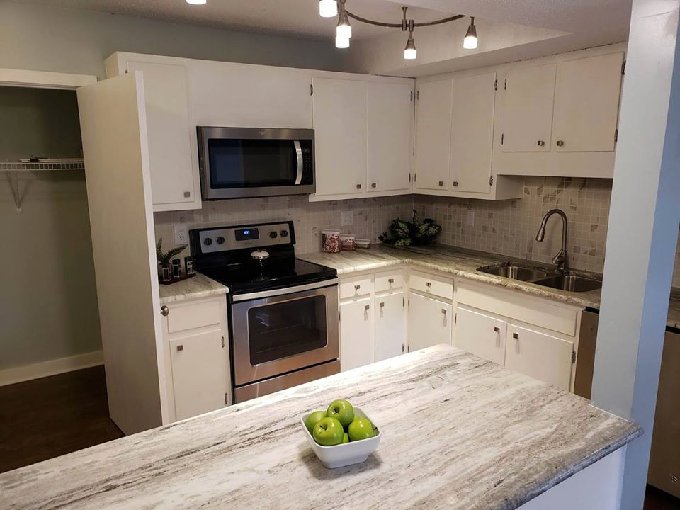 Mid-sized transitional u-shaped medium tone wood floor and brown floor eat-in kitchen photo in Raleigh with an undermount sink, shaker cabinets, white cabinets, granite countertops, multicolored backsplash, ceramic backsplash, stainless steel appliances, an island and multicolored countertops