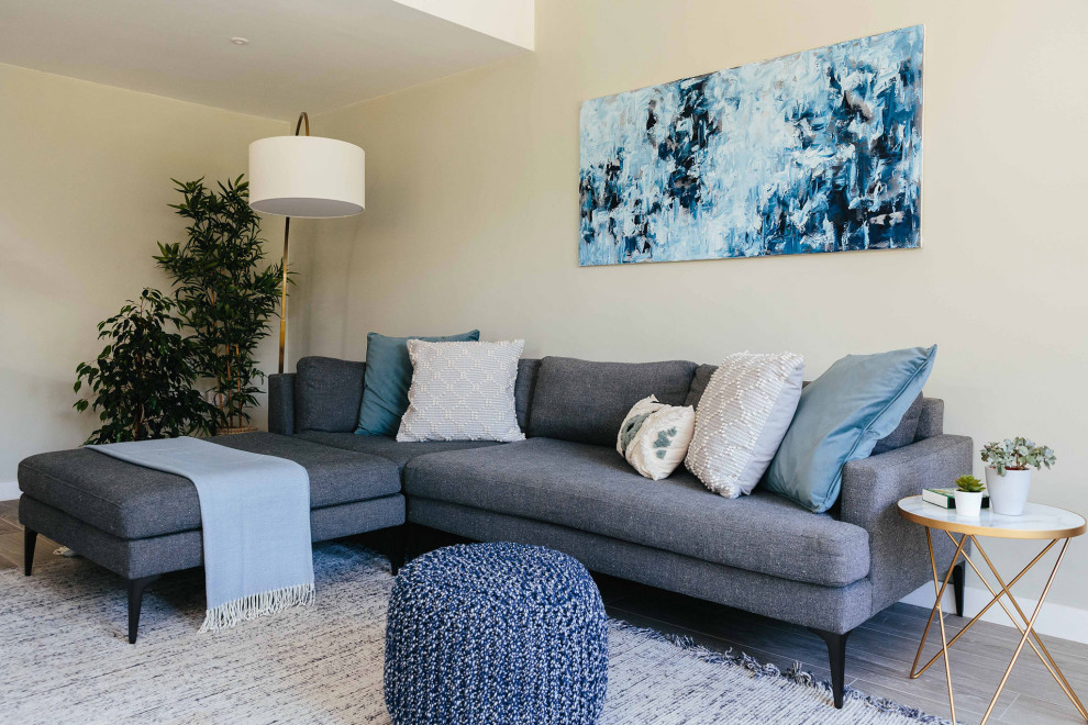 Esempio di un soggiorno nordico di medie dimensioni e aperto con pareti grigie, parquet chiaro, stufa a legna, TV a parete e pavimento grigio