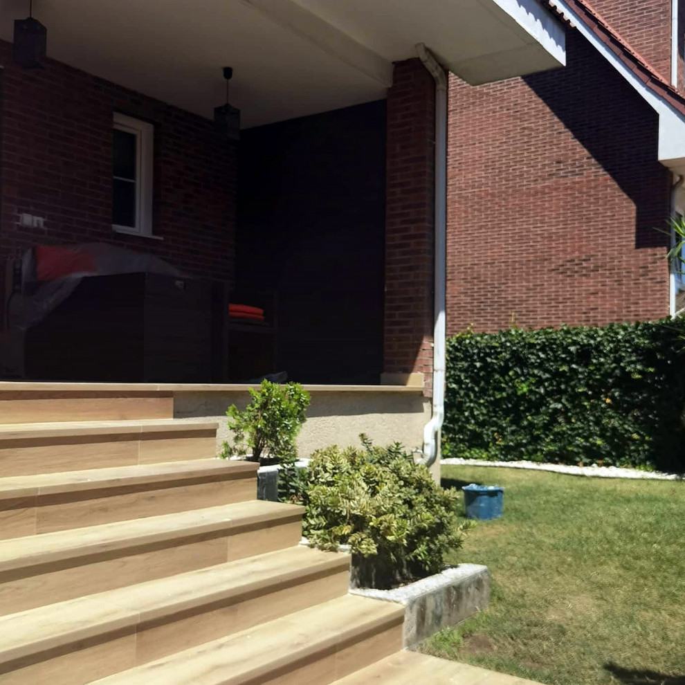 Photo of a small modern front driveway partial sun garden in Madrid with a pathway and decking.
