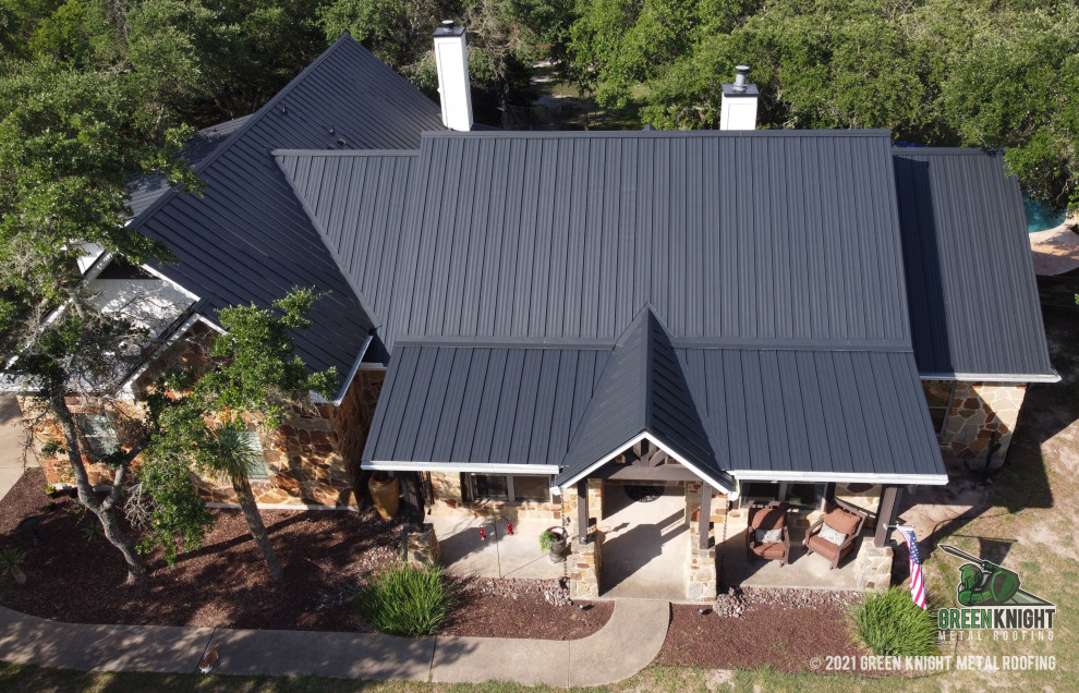 Mid-sized traditional exterior home idea in Austin with a metal roof and a black roof