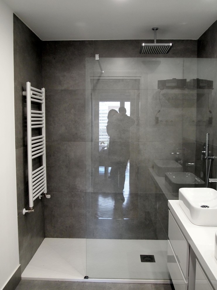 Modelo de cuarto de baño contemporáneo con ducha a ras de suelo, sanitario de una pieza, baldosas y/o azulejos grises, baldosas y/o azulejos de cerámica, paredes grises, suelo de baldosas de cerámica, aseo y ducha, lavabo sobreencimera, encimera de cuarzo compacto, suelo gris y encimeras blancas