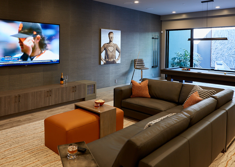 Inspiration for a contemporary family room in San Francisco with a game room, brown walls, medium hardwood floors, a wall-mounted tv and brown floor.