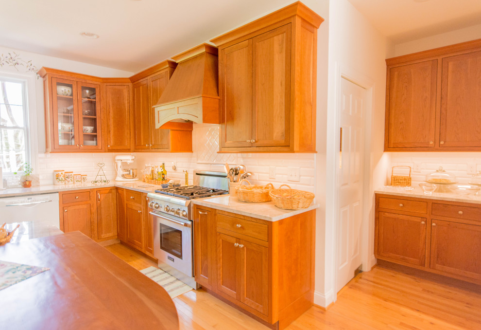 Mid-sized traditional u-shaped eat-in kitchen in DC Metro with a double-bowl sink, flat-panel cabinets, medium wood cabinets, quartzite benchtops, white splashback, subway tile splashback, white appliances, medium hardwood floors, with island, brown floor and beige benchtop.