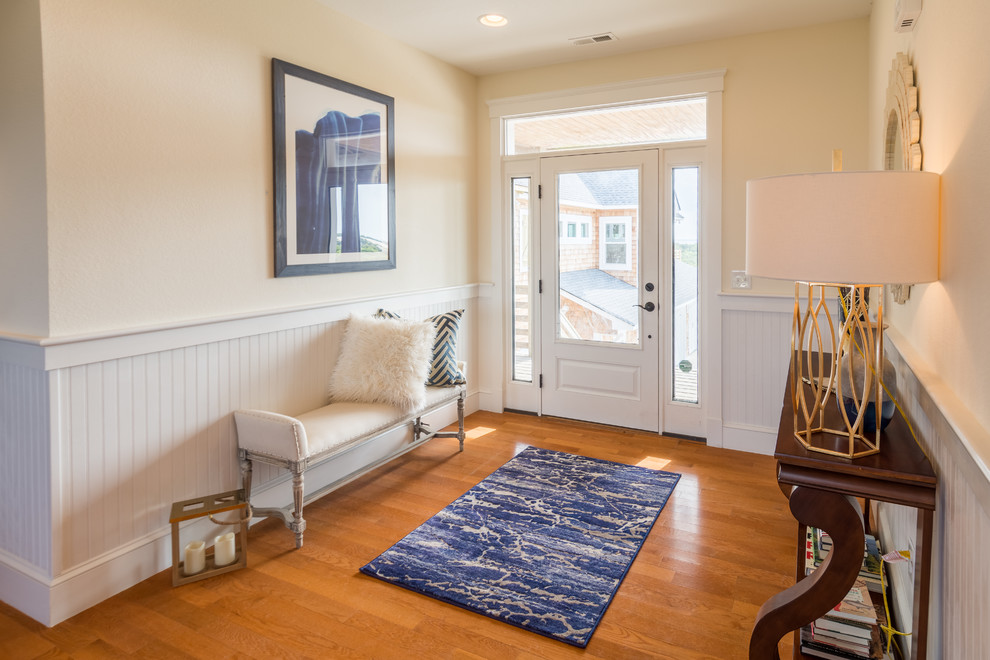 This is an example of a mid-sized contemporary foyer in Other with beige walls, medium hardwood floors, a single front door, a white front door and brown floor.