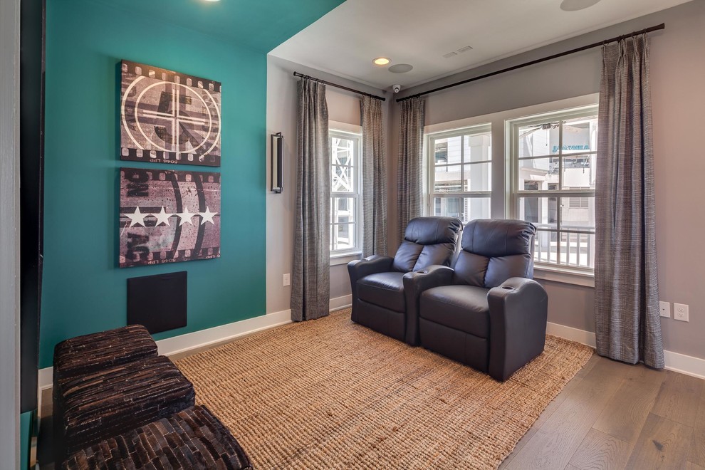 Inspiration for a mid-sized transitional open concept home theatre in Jacksonville with a wall-mounted tv, multi-coloured walls and light hardwood floors.