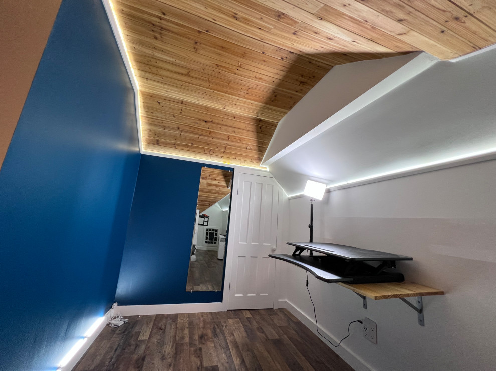 This is an example of a large contemporary gender neutral walk-in wardrobe in Other with open cabinets, white cabinets, laminate floors, brown floors and a vaulted ceiling.