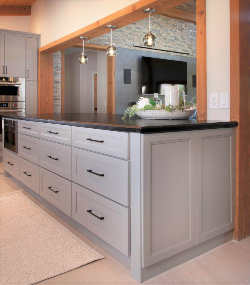 Large mountain style galley porcelain tile, gray floor and wood ceiling open concept kitchen photo in Denver with an undermount sink, recessed-panel cabinets, gray cabinets, quartzite countertops, white backsplash, cement tile backsplash, stainless steel appliances, an island and white countertops