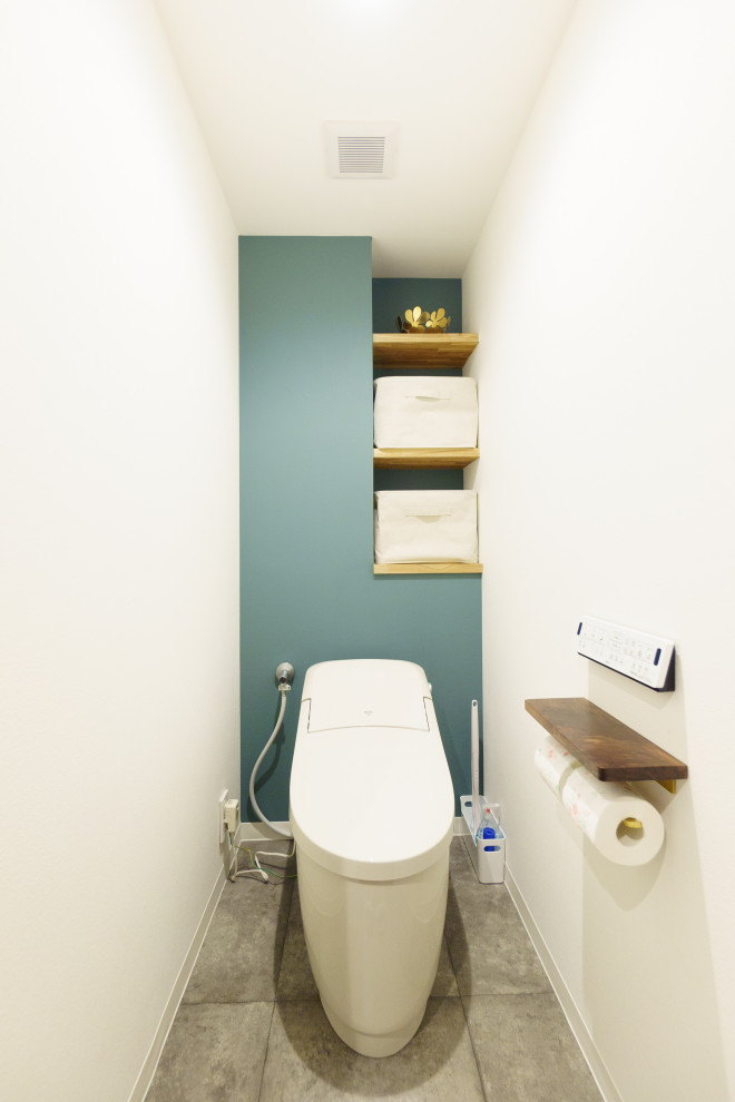 Diseño de aseo blanco nórdico con sanitario de una pieza, baldosas y/o azulejos verdes, suelo gris, papel pintado y papel pintado