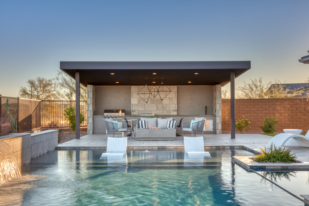 Imagen de piscina alargada moderna grande a medida en patio trasero con paisajismo de piscina y entablado