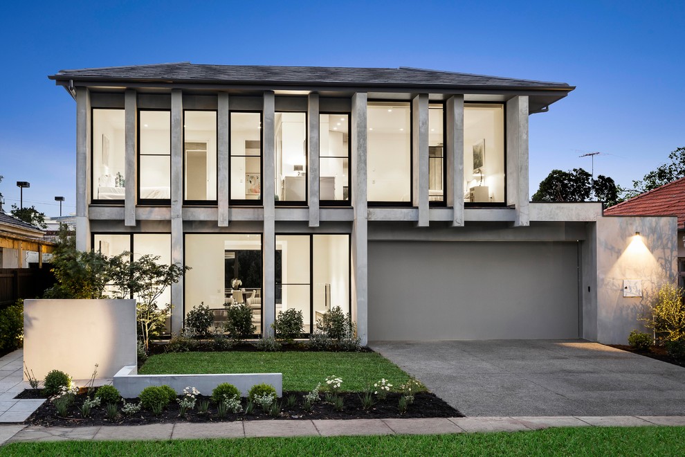 Photo of a large contemporary two-storey concrete grey house exterior in Melbourne with a hip roof and a shingle roof.