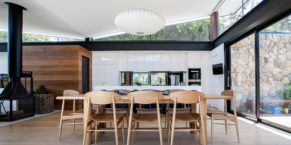 Mid-sized contemporary kitchen/dining combo in Melbourne with white walls and medium hardwood floors.