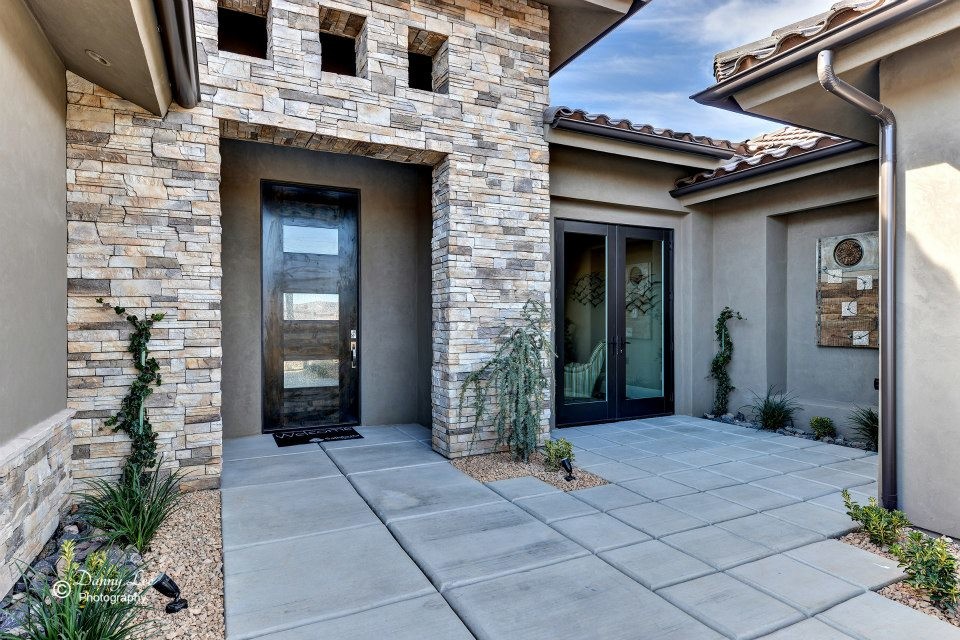 Photo of a mid-sized contemporary one-storey stucco brown house exterior in Salt Lake City with a hip roof and a tile roof.